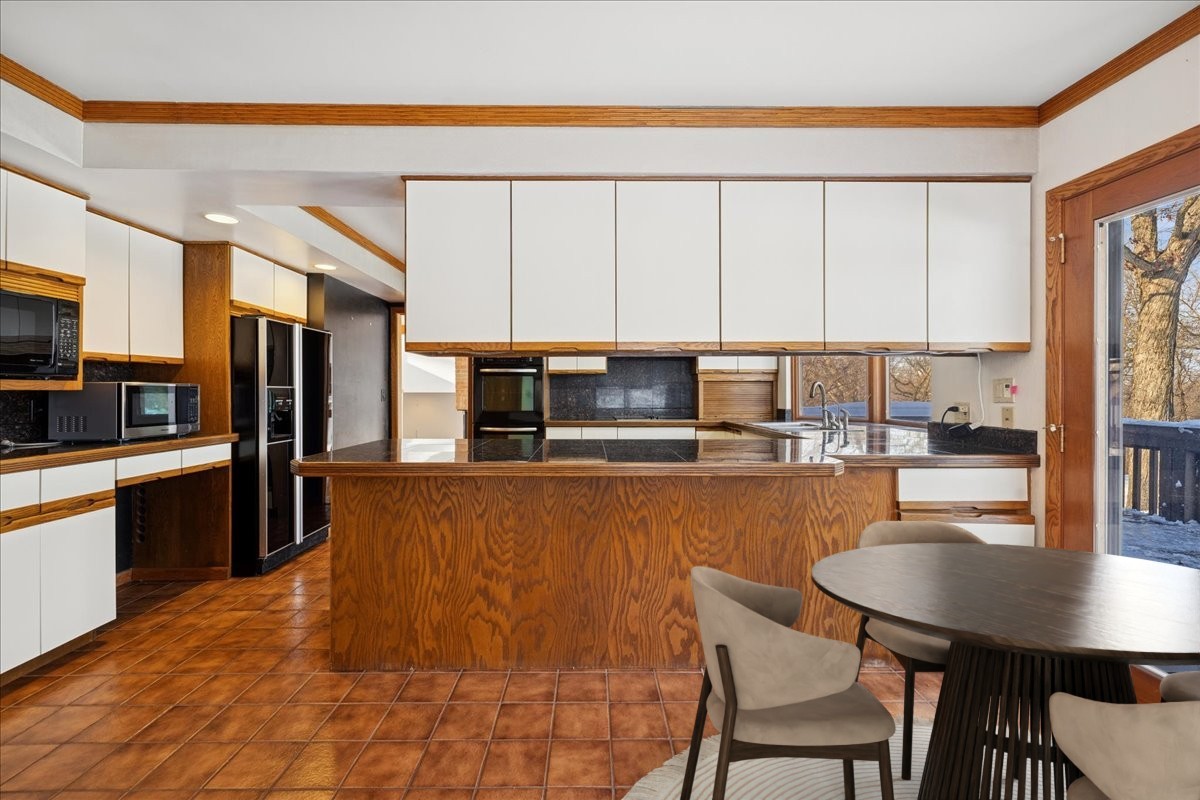 43W880 Pathfinder Drive Maple Park, IL 60151 - Photo 10 of 38 a kitchen with stainless steel appliances a stove a sink a microwave a dining table and chairs