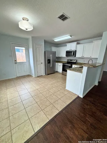 a view of kitchen with microwave and cabinets