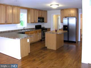94 Harvard Road Pennsville, NJ 08070 - Photo 3 of 6 a kitchen with a refrigerator and a stove top oven