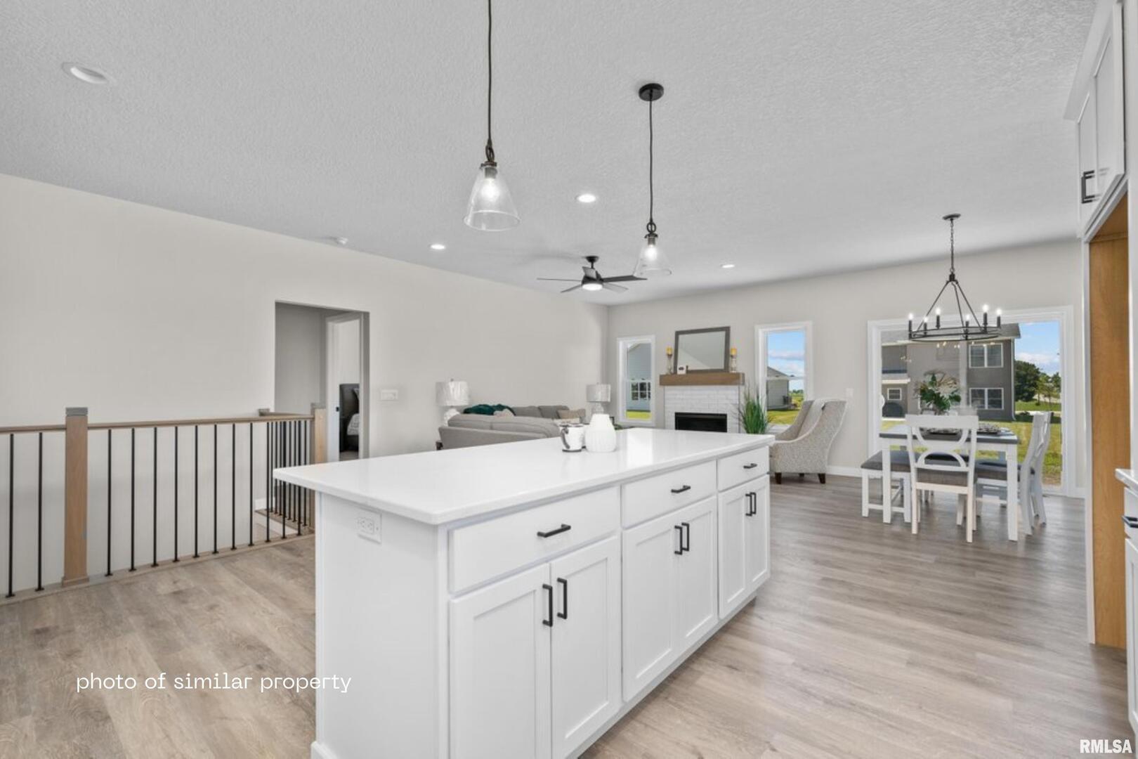 1867 Redbud Circle, Unit 102 Eldridge, IA 52748 - Photo 7 of 15 a large white kitchen with a large island oven a sink stainless steel appliances and cabinets