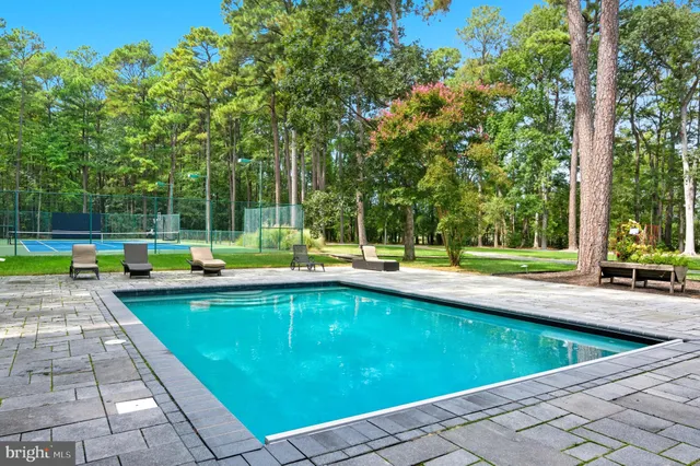 a view of a patio with dining table and chairs under an umbrella