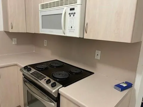 a stove top oven sitting inside of a kitchen