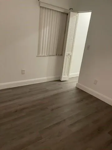 an empty room with wooden floor and stairs