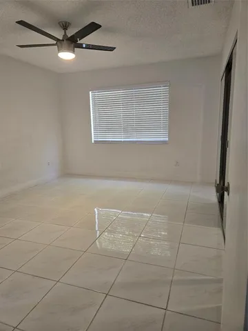a view of a livingroom with an empty space and a window