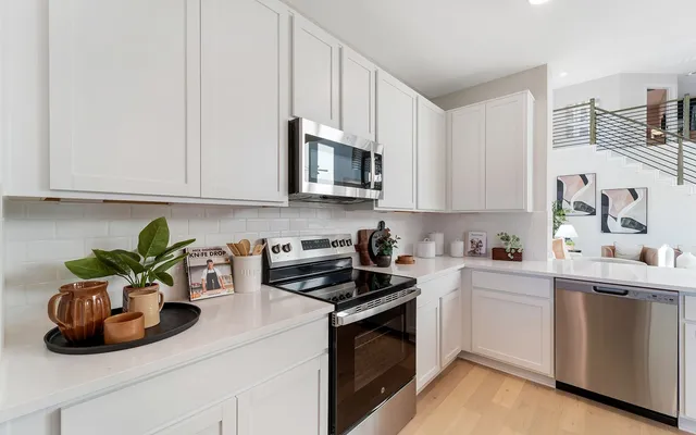 a kitchen with granite countertop a sink a stove and cabinets