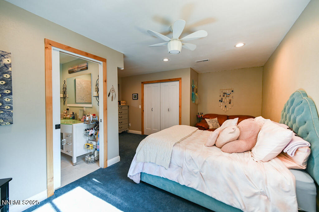 1147 Autumn Hills Road Gardnerville, NV 89460 - Photo 38 of 50 a bedroom with a large bed and a chandelier