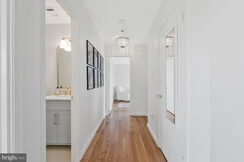 a view of a hallway with wooden floor and staircase