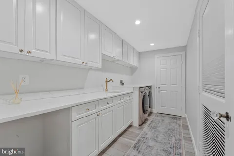 a kitchen with white cabinets and sink