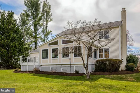 a view of a house with a big yard and large trees