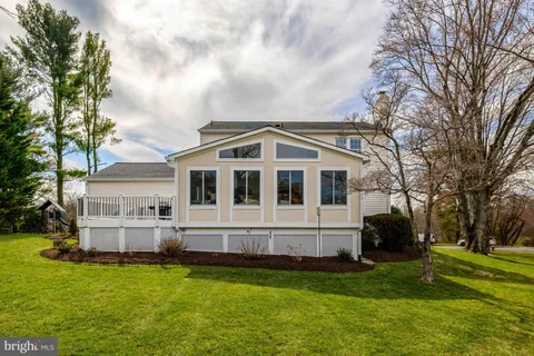 a view of a house with a big yard and large trees