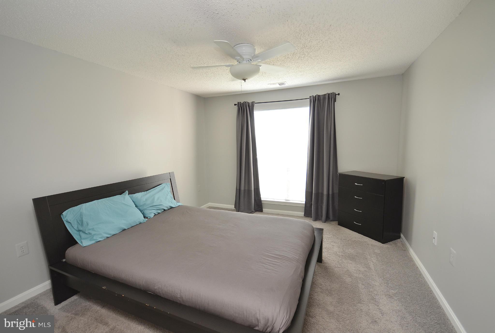 21019 Timber Ridge Terrace, Unit 302 Ashburn, VA 20147 - Photo 16 of 27 a bedroom with a bed and a large window