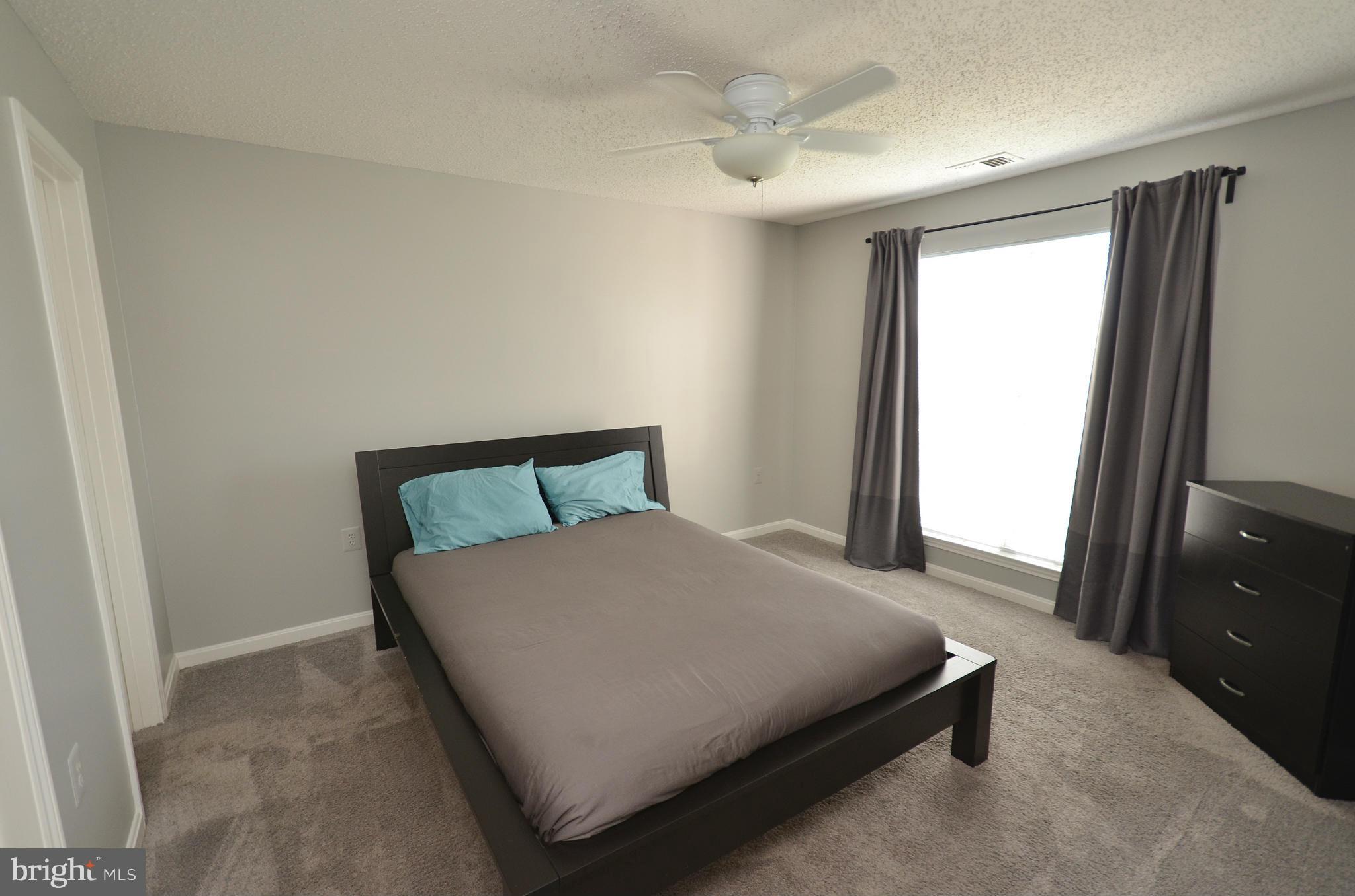 21019 Timber Ridge Terrace, Unit 302 Ashburn, VA 20147 - Photo 17 of 27 a large bed sitting in a bedroom next to a window