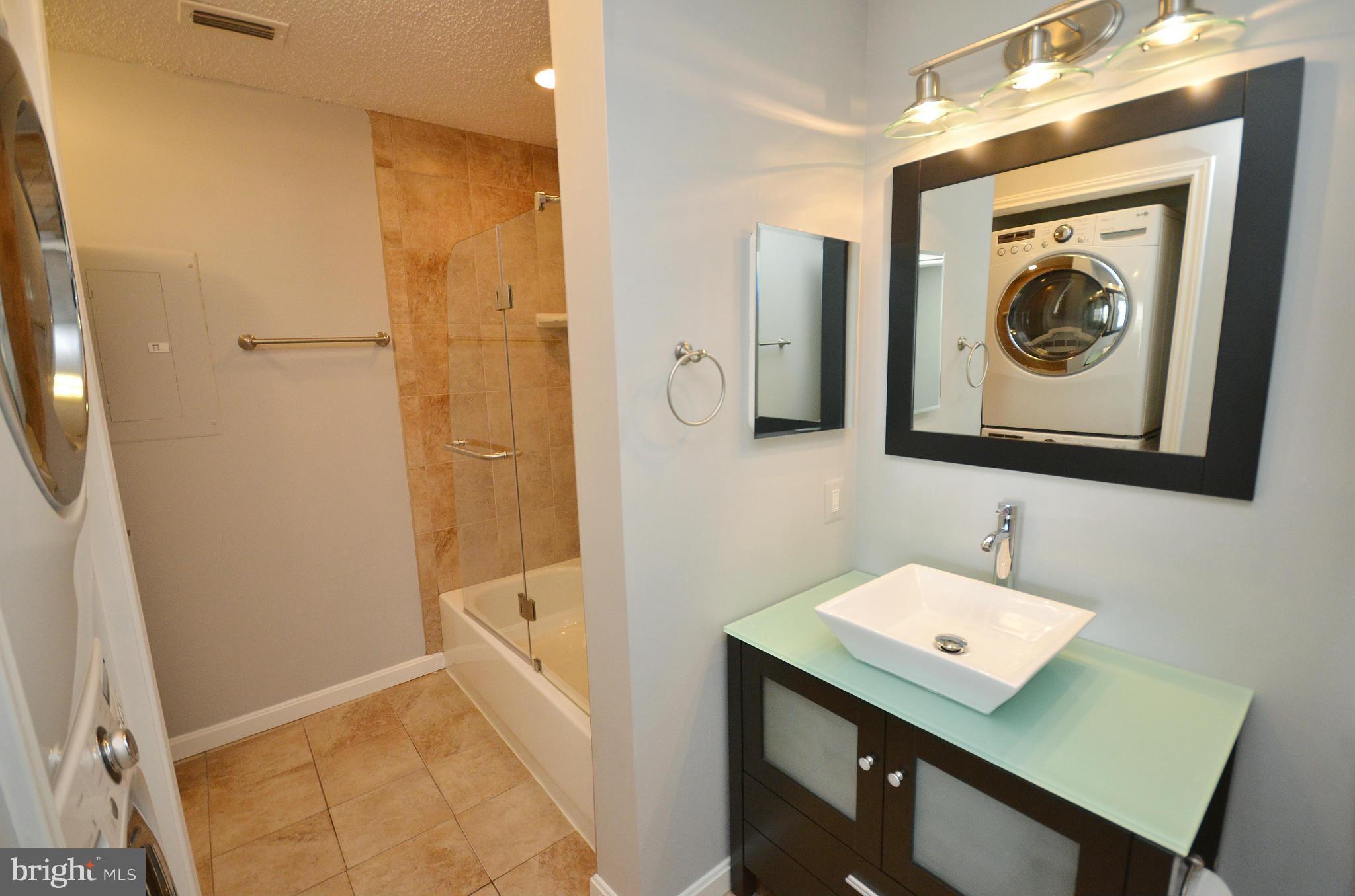21019 Timber Ridge Terrace, Unit 302 Ashburn, VA 20147 - Photo 19 of 27 a bathroom with a sink a mirror and a shower