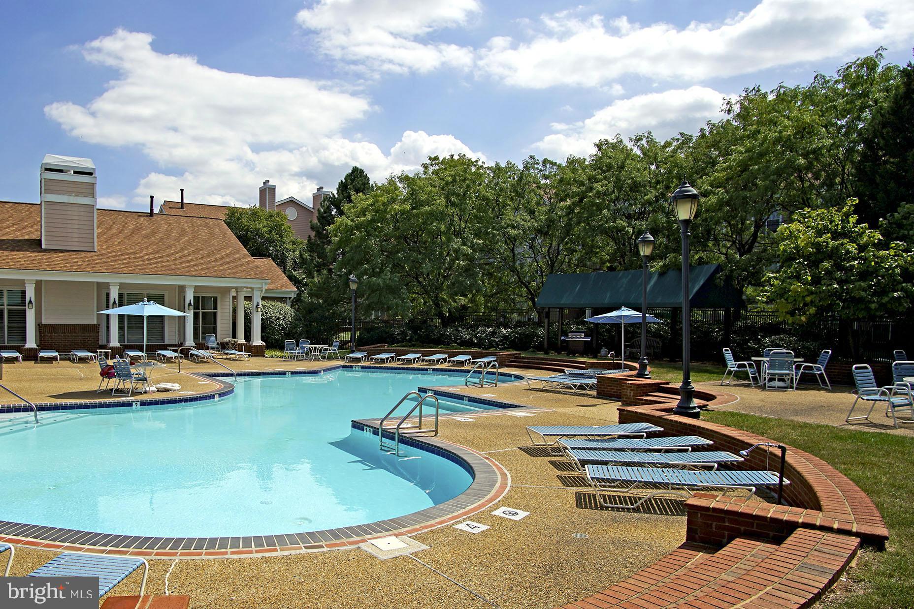 21019 Timber Ridge Terrace, Unit 302 Ashburn, VA 20147 - Photo 26 of 27 a view of a swimming pool with lounge chairs