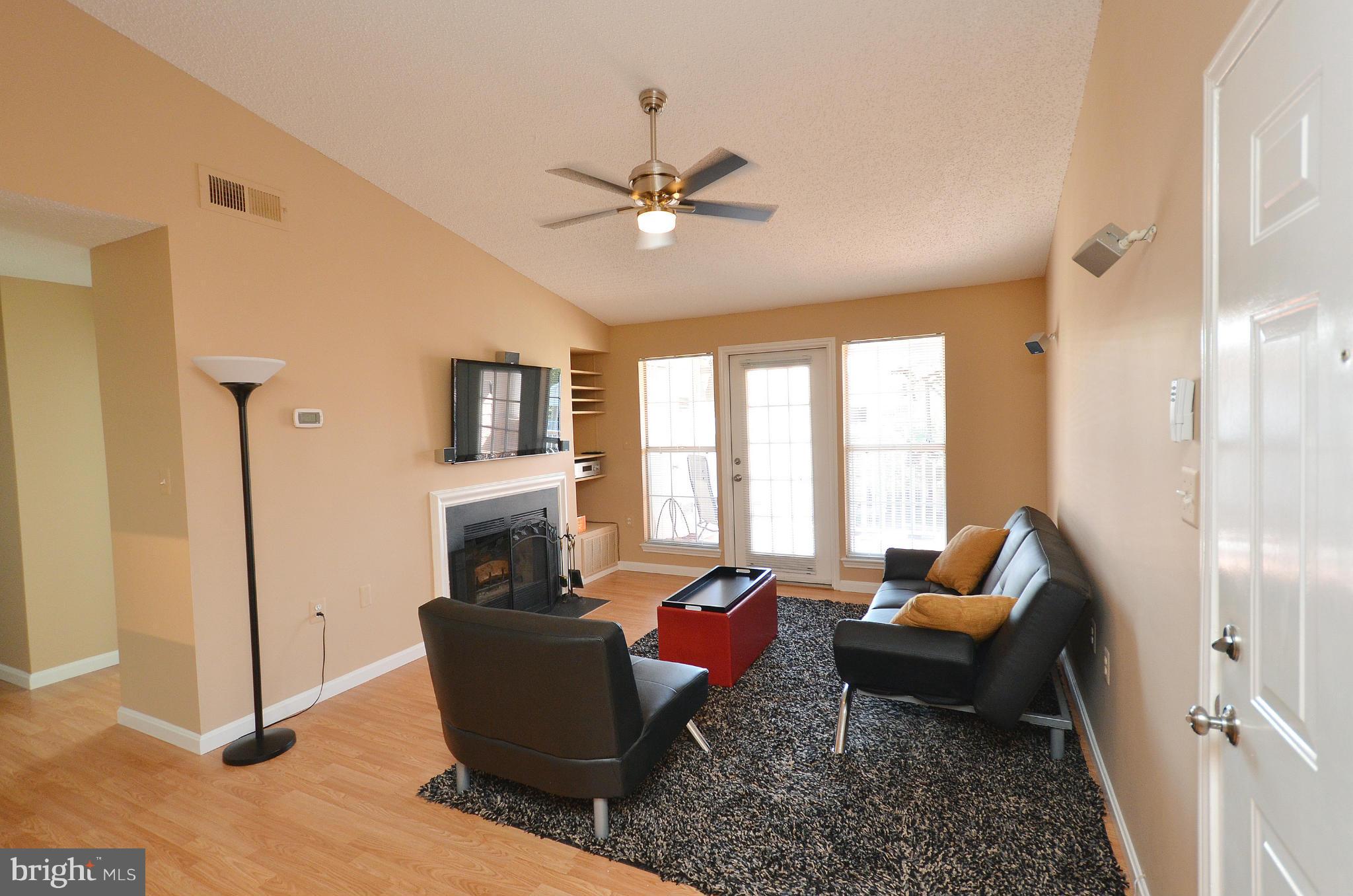 21019 Timber Ridge Terrace, Unit 302 Ashburn, VA 20147 - Photo 7 of 27 a living room with furniture and a fireplace