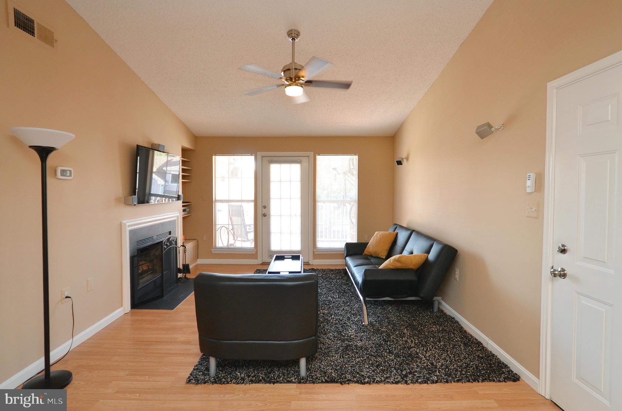 21019 Timber Ridge Terrace, Unit 302 Ashburn, VA 20147 - Photo 8 of 27 a living room with furniture and a fireplace