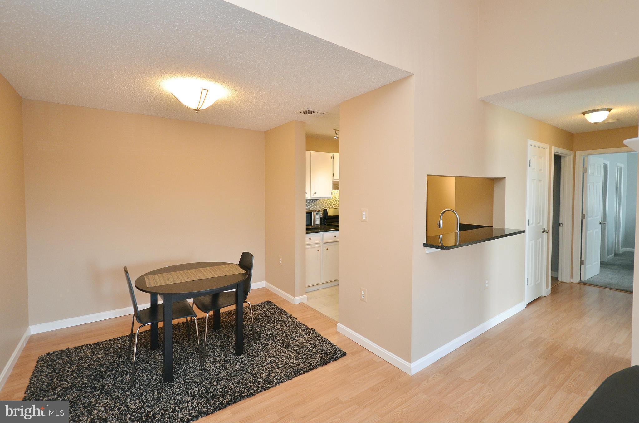 21019 Timber Ridge Terrace, Unit 302 Ashburn, VA 20147 - Photo 9 of 27 a view of a hallway with wooden floor and a bathroom
