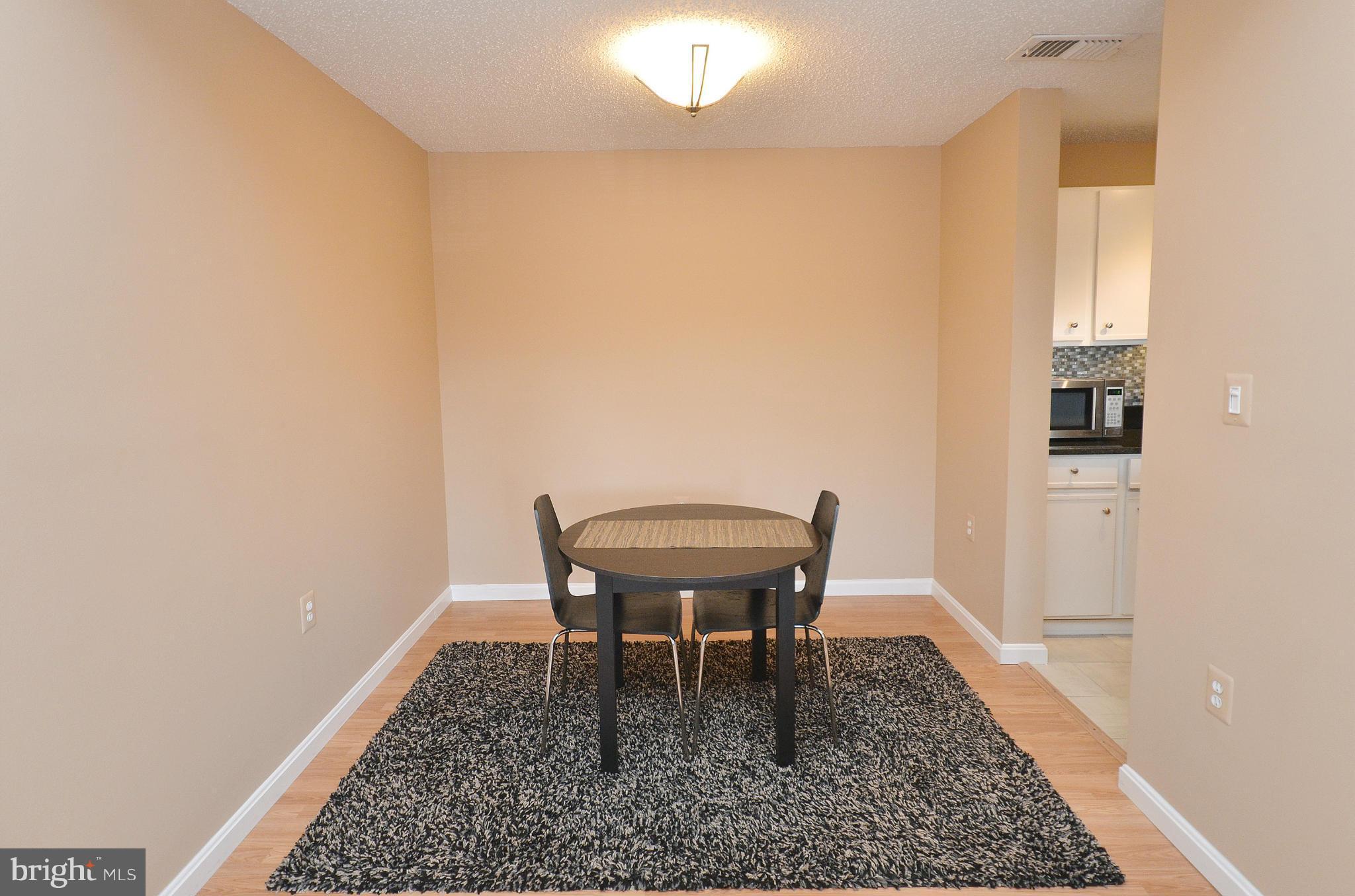 21019 Timber Ridge Terrace, Unit 302 Ashburn, VA 20147 - Photo 10 of 27 a view of a dining room with furniture and wooden floor