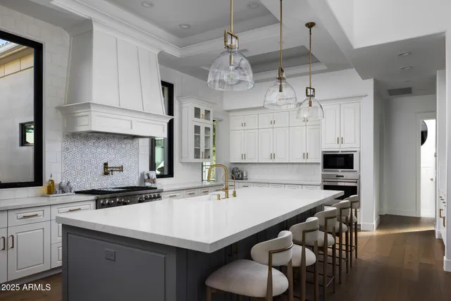 a kitchen with a kitchen island white cabinetry and stainless steel appliances