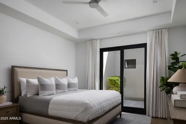 a bedroom with a large bed and a potted plant