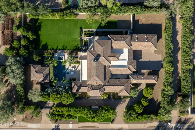 an aerial view of a house with a garden and lake view