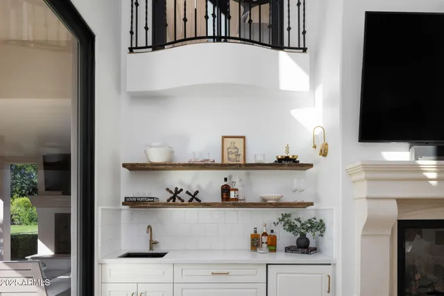 a view of white cabinet with plants and knick knacks on it