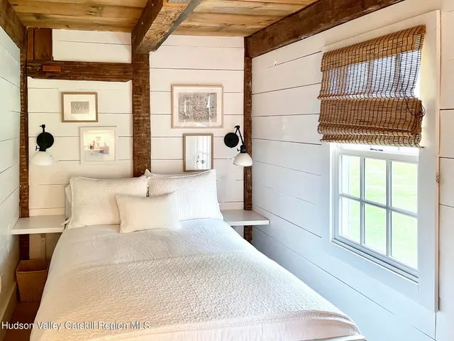 a bed room with a bed mirror and a window