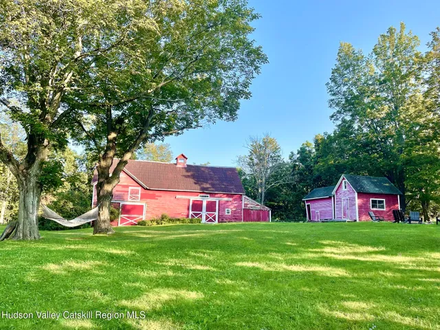 a view of backyard with swimming pool and green space