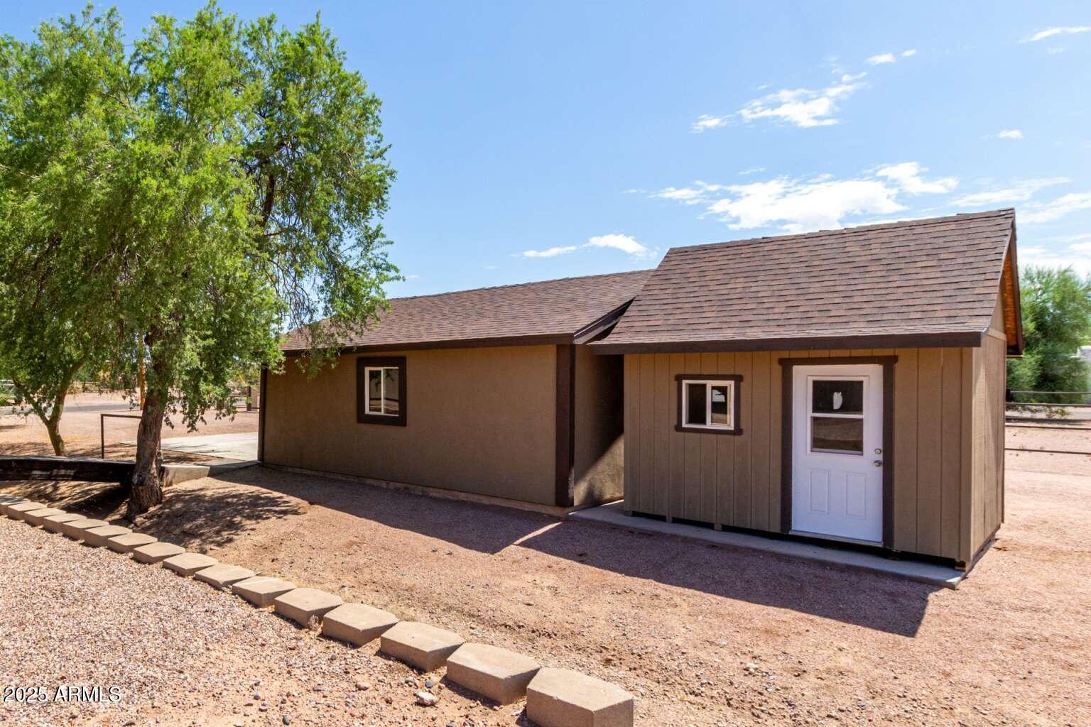 2009 South Raindance Road Apache Junction, AZ 85119 - Photo 49 of 60 a front view of a house with a yard and garage