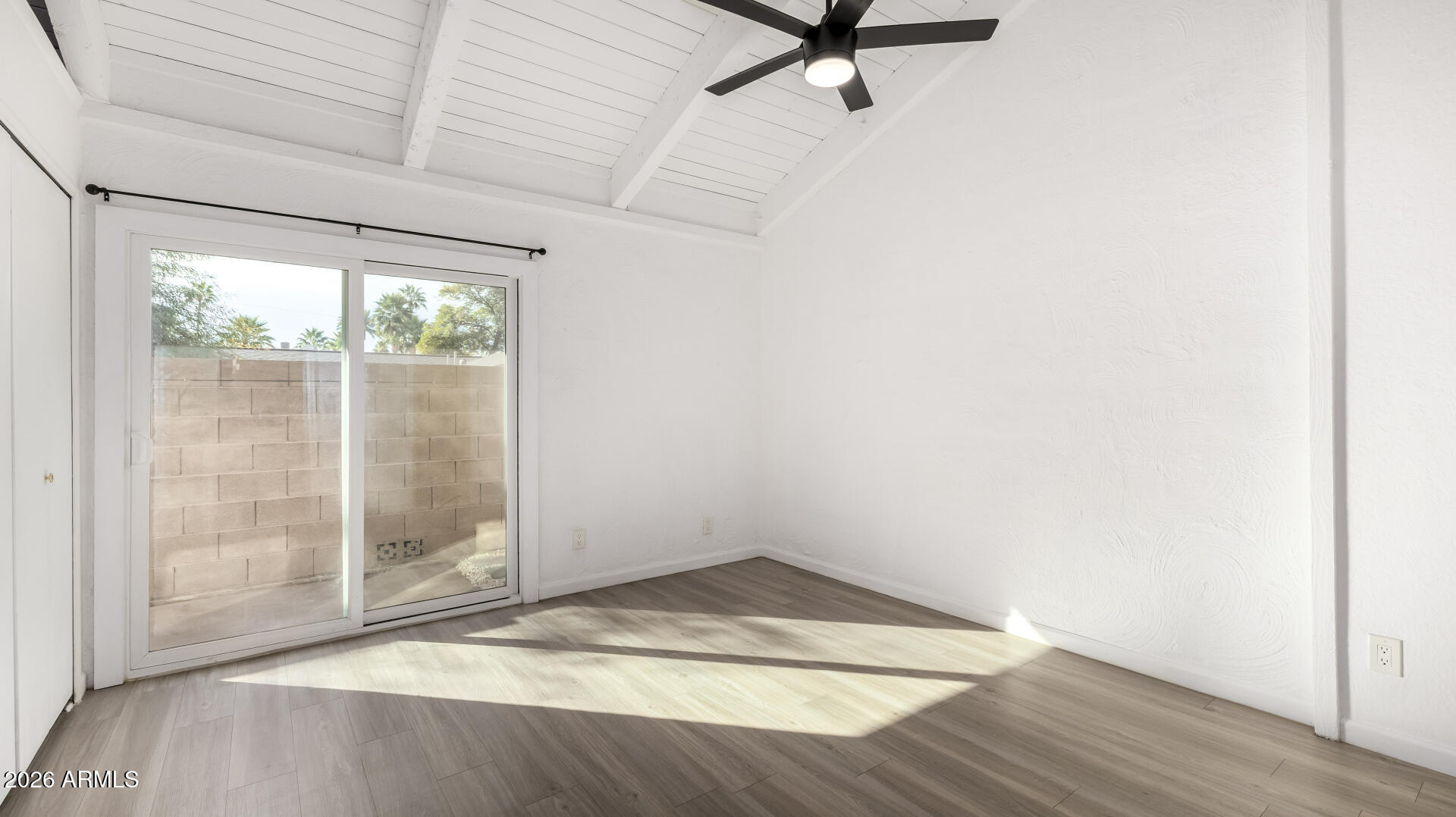 1149 East Rovey Avenue Phoenix, AZ 85014 - Photo 13 of 25 an empty room with wooden floor and windows