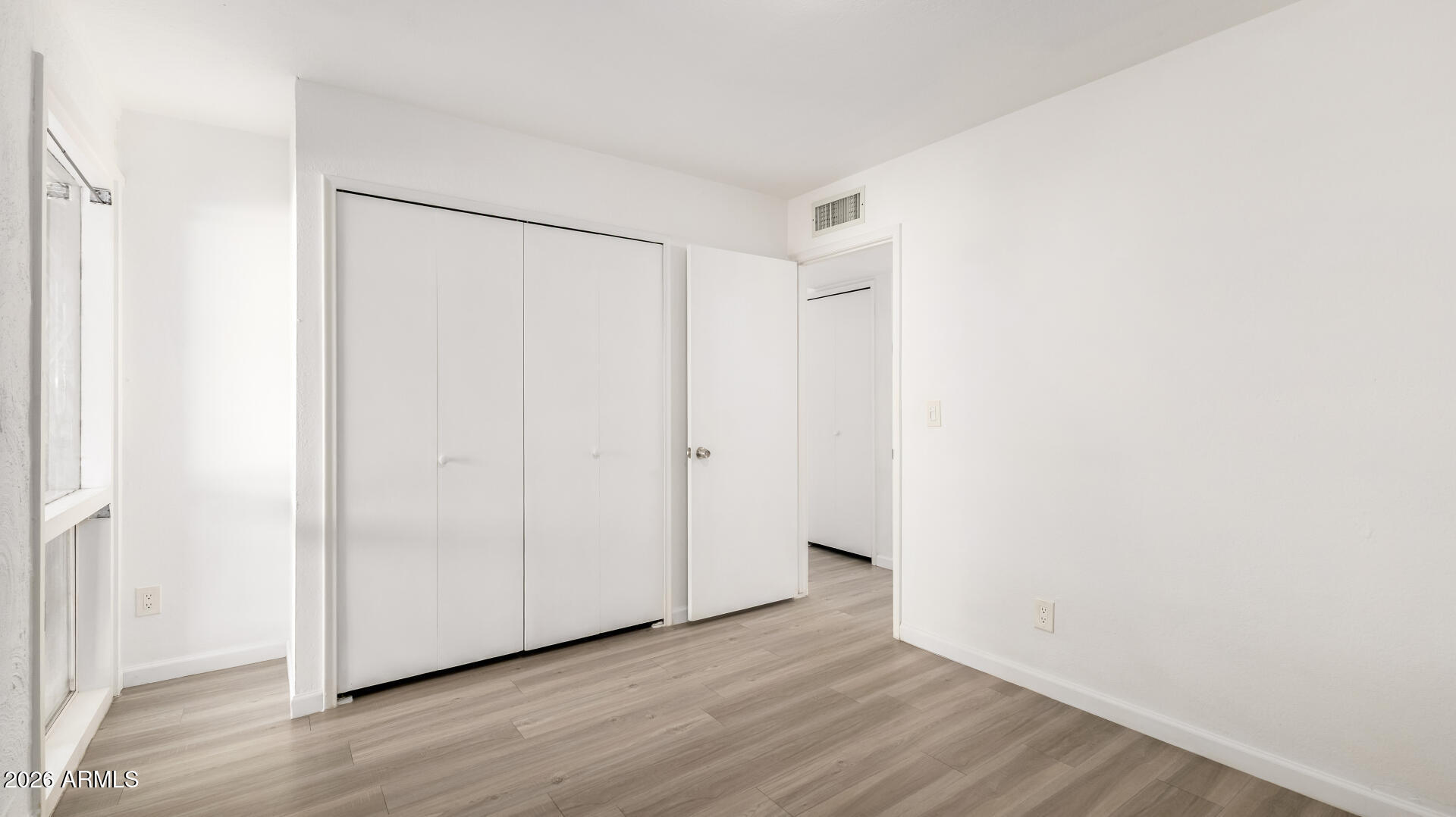 1149 East Rovey Avenue Phoenix, AZ 85014 - Photo 18 of 25 a view of an empty room with wooden floor