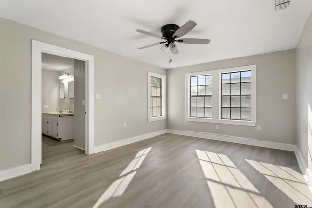 a view of an empty room and window and wooden floor