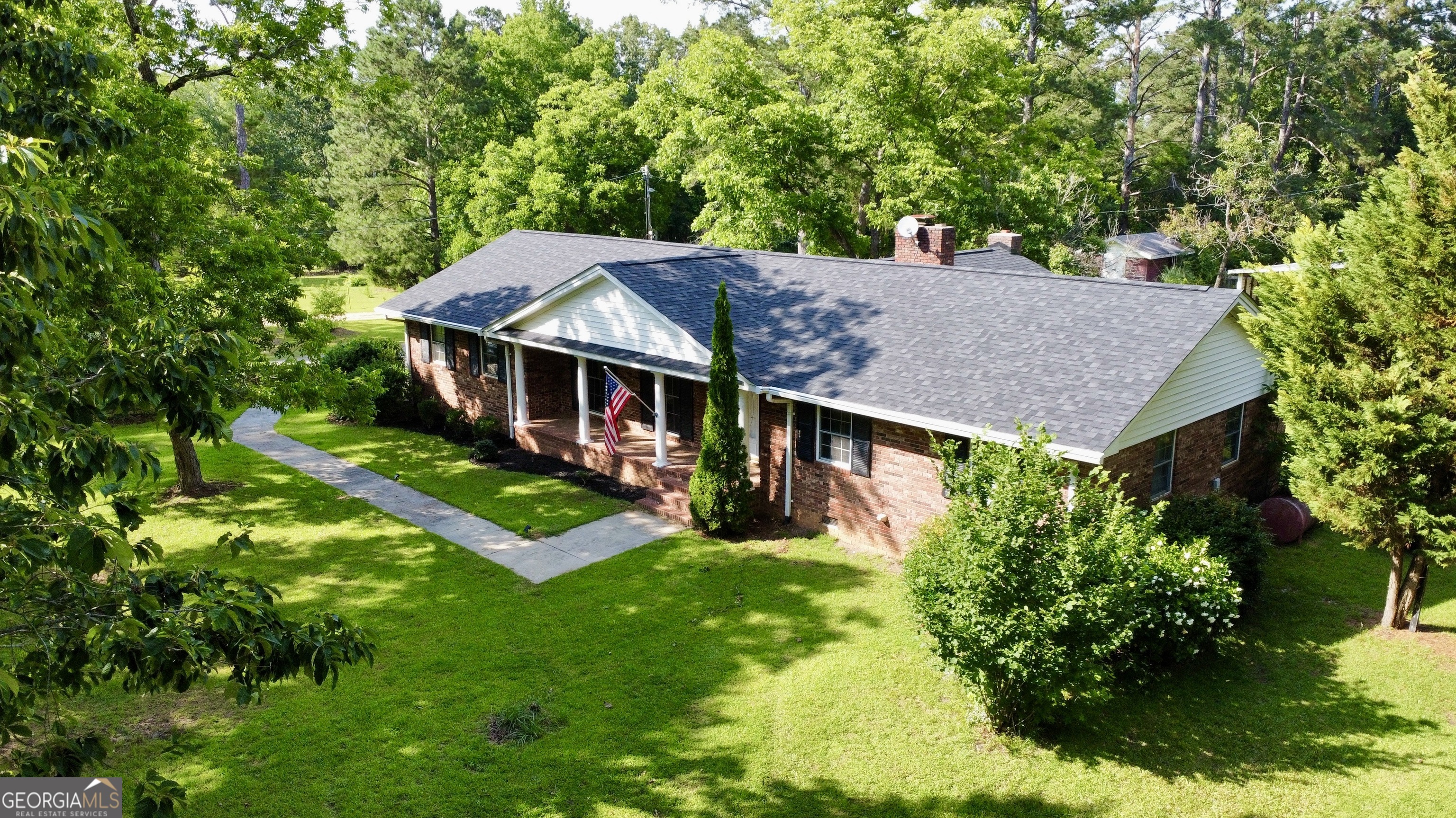 an aerial view of a house with swimming pool and green space