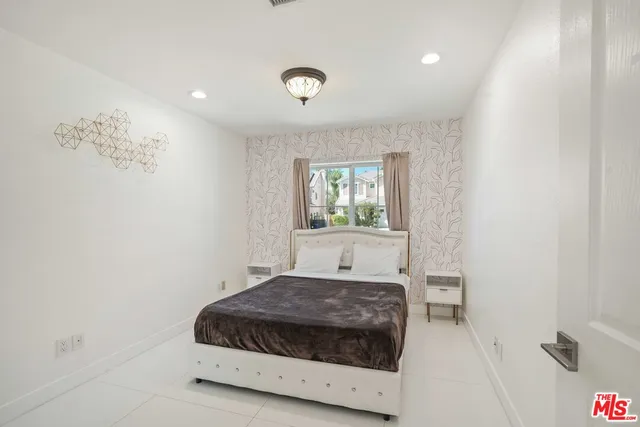 a kitchen with stainless steel appliances kitchen island granite countertop a refrigerator and a stove top oven with white countertops