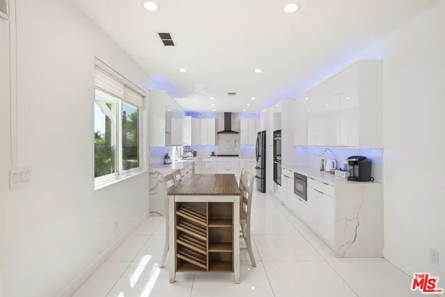 a large kitchen with stainless steel appliances lots of counter space and a sink