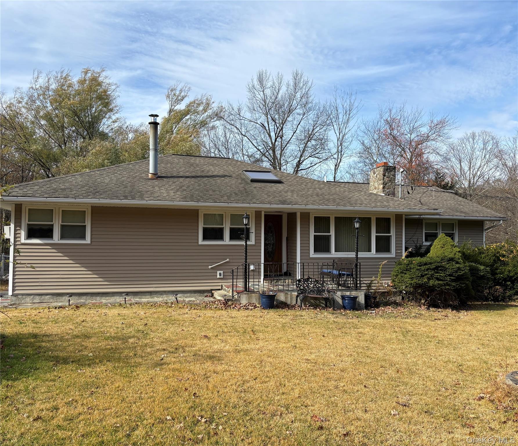 a front view of house with yard space and trees in the background