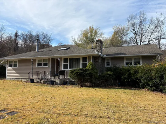a front view of house with yard and trees around