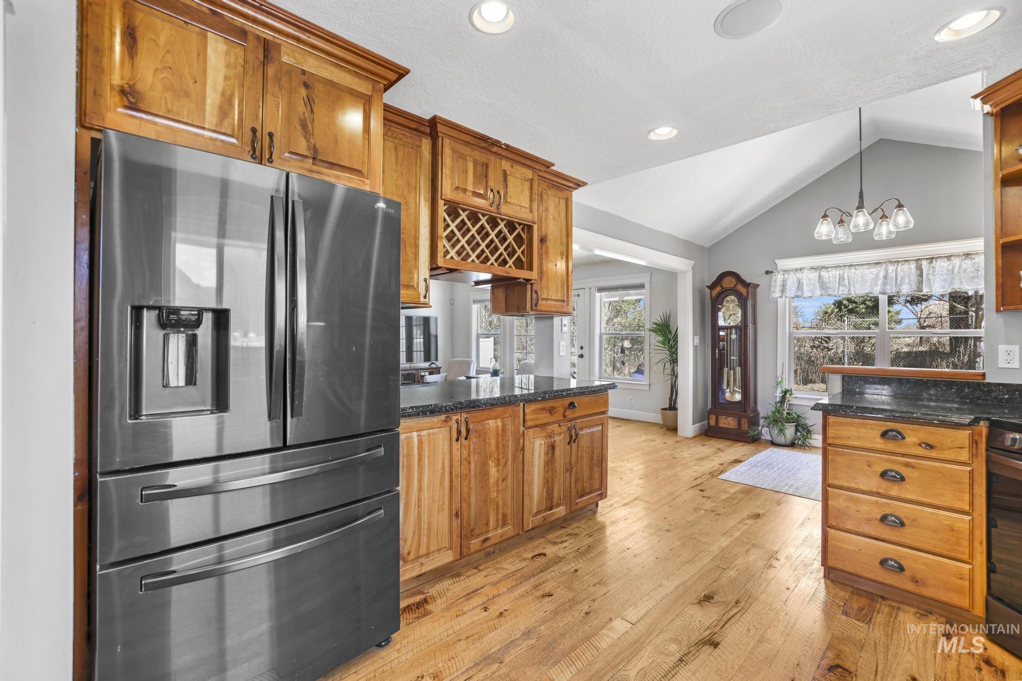 1111 Cole Street Kimberly, ID 83341 - Photo 13 of 46 Kitchen with stainless steel fridge with ice dispenser, wood finish cabinetry, light wood-style floors, and suspended lighting
