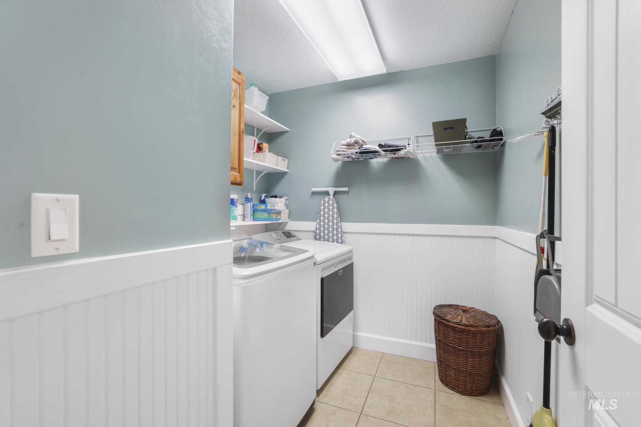 1111 Cole Street Kimberly, ID 83341 - Photo 24 of 46 Laundry area featuring a wainscoted wall, separate washer and dryer, and light tile patterned flooring