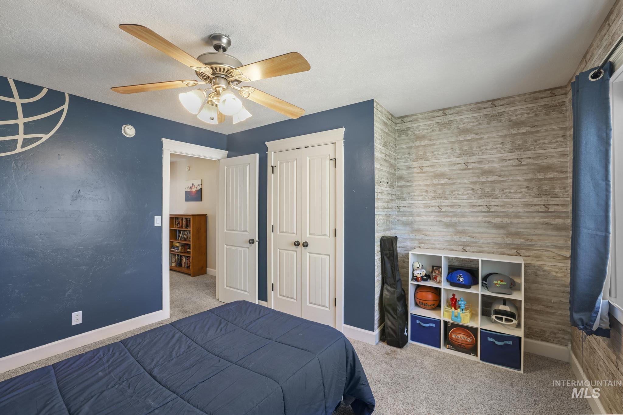 1111 Cole Street Kimberly, ID 83341 - Photo 31 of 46 Bedroom featuring carpet, a ceiling fan, an accent wall, and a textured ceiling
