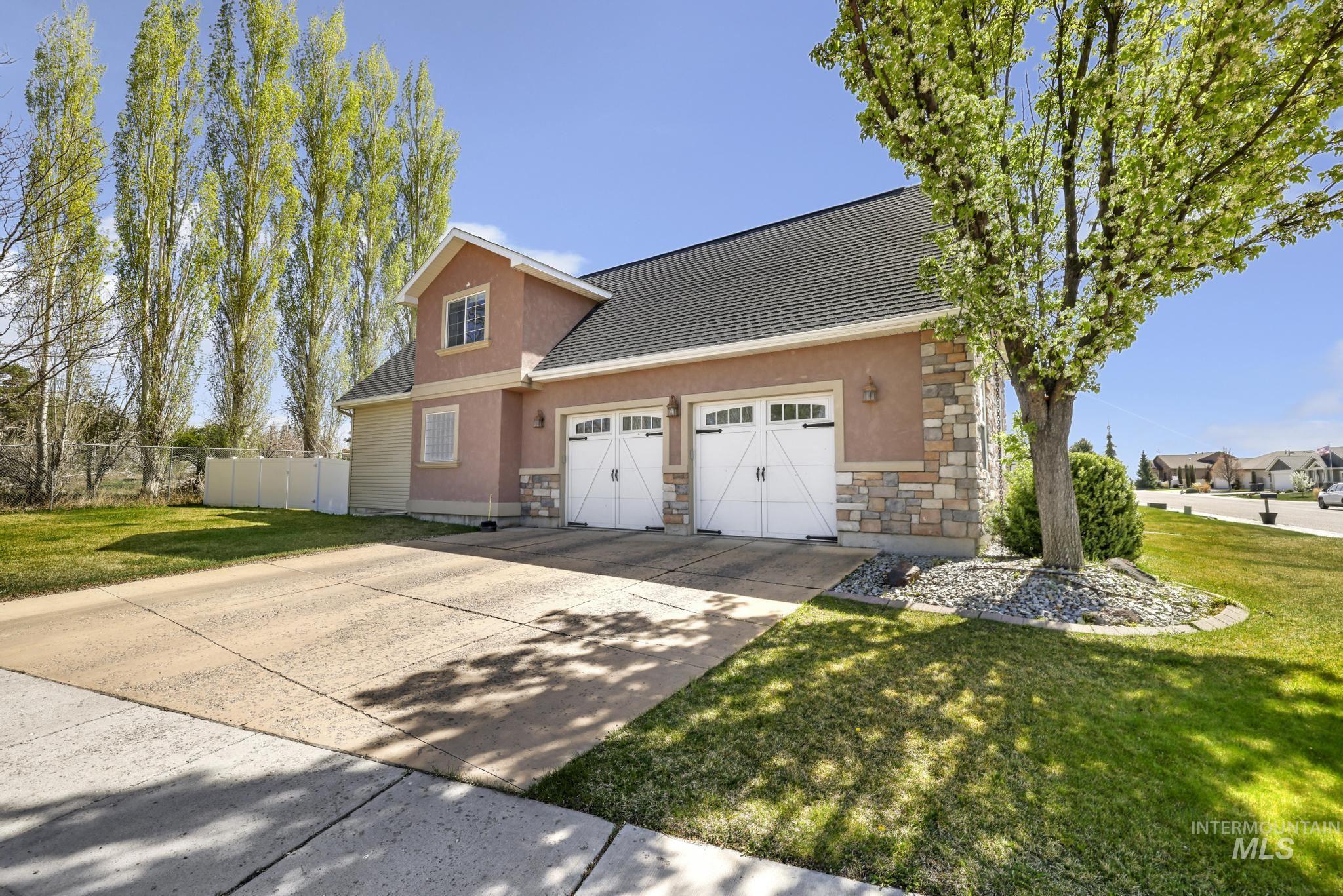 1111 Cole Street Kimberly, ID 83341 - Photo 43 of 46 View of front of house with stone siding, a garage, driveway, and stucco siding