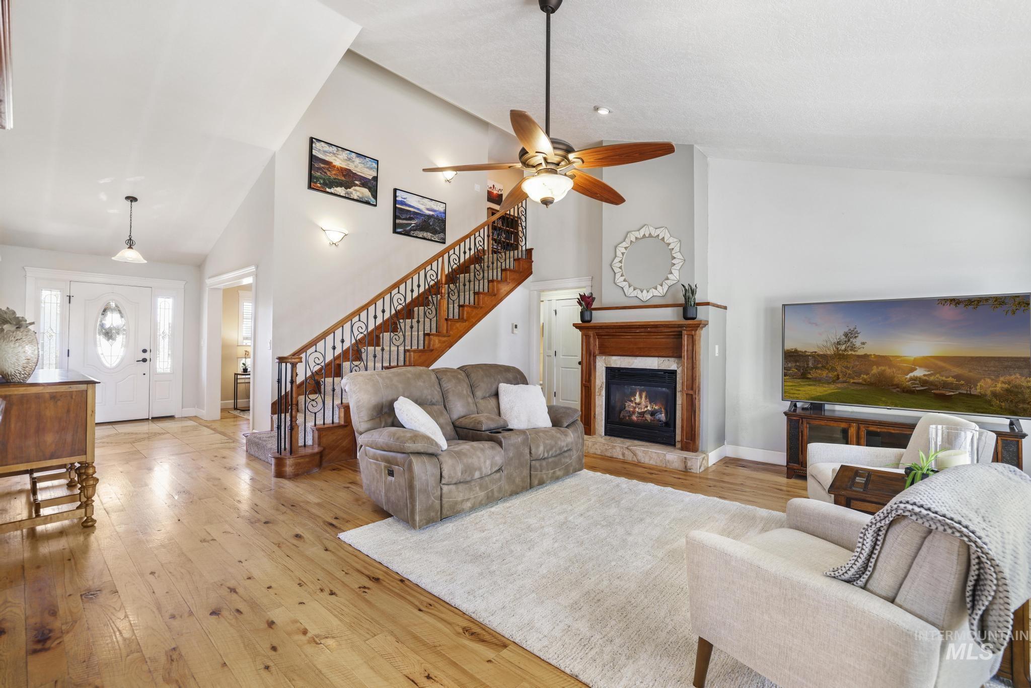 1111 Cole Street Kimberly, ID 83341 - Photo 5 of 46 Living room with light wood finished floors, vaulted ceiling, a lit fireplace, and a ceiling fan