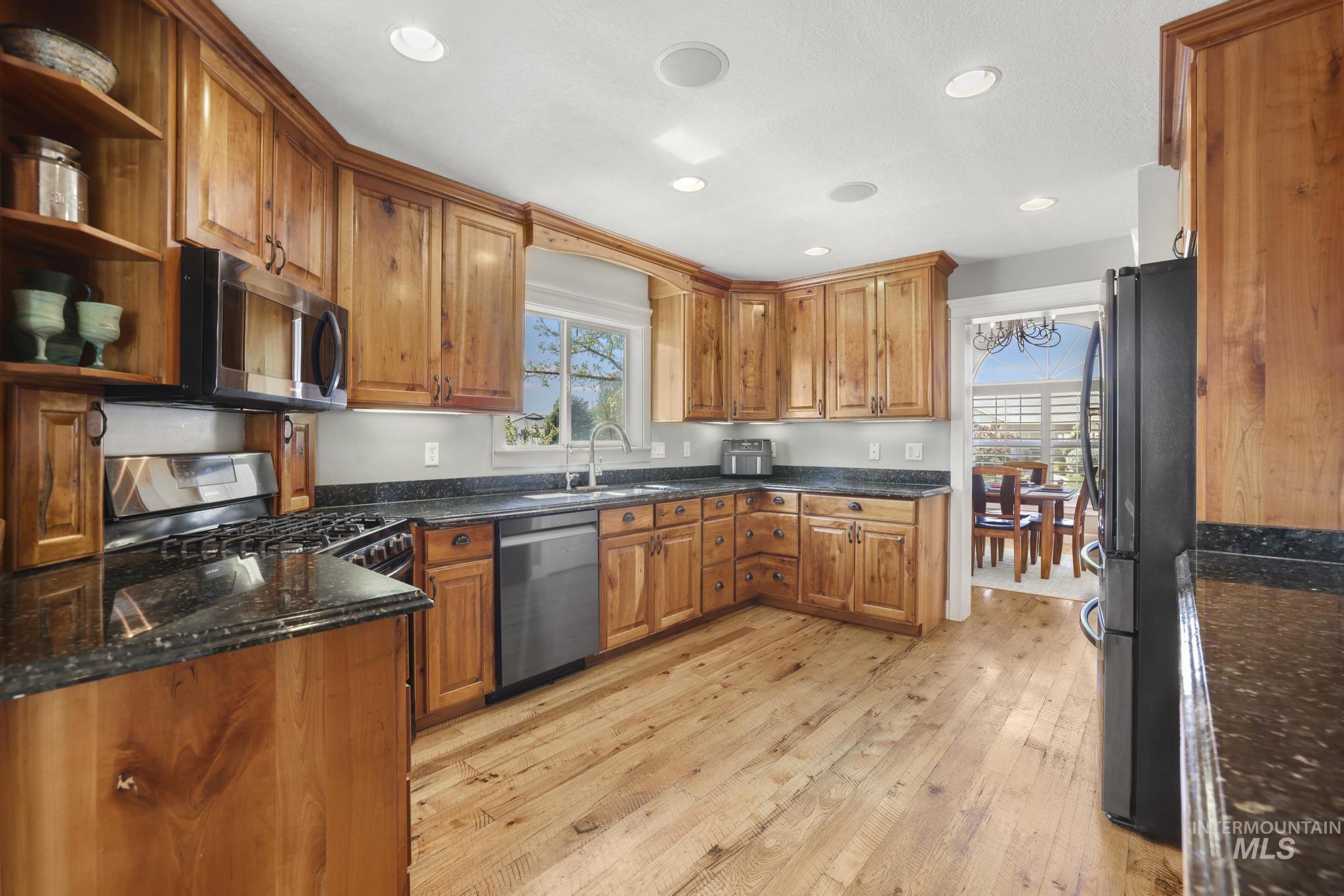 1111 Cole Street Kimberly, ID 83341 - Photo 10 of 46 Kitchen featuring wood finish cabinets, stainless steel appliances, dark stone counters, light wood-type flooring, and recessed lighting