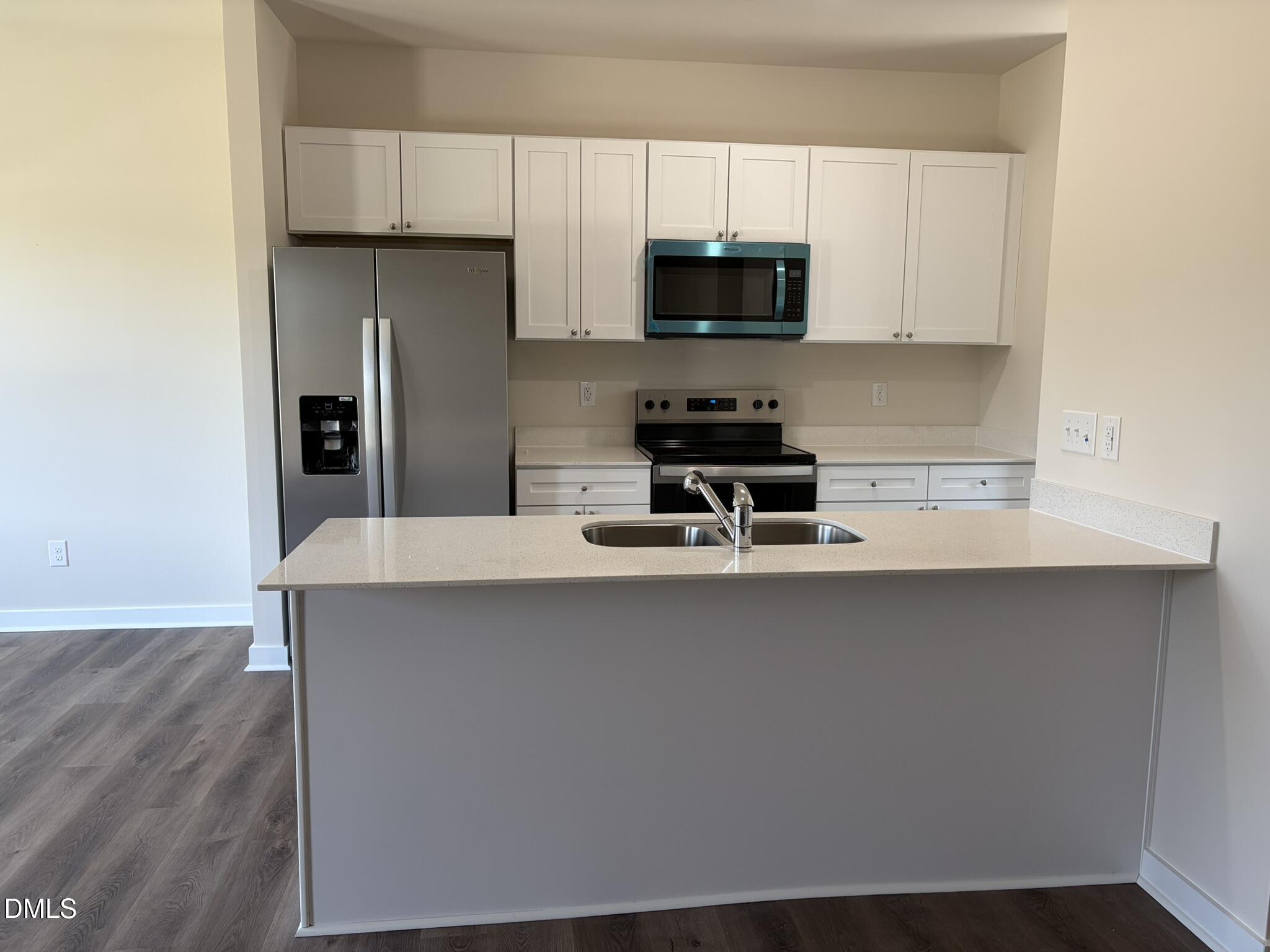 159 Jacobs Ridge Drive Four Oaks, NC 27524 - Photo 5 of 18 a kitchen with stainless steel appliances a sink a stove a microwave and cabinets