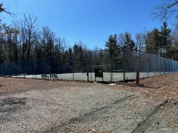 a view of a backyard with a fence and trees