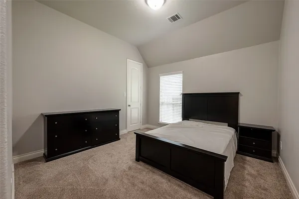 a bedroom with a bed and a dresser