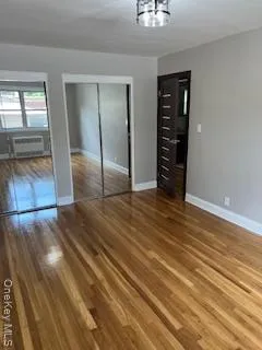 an empty room with wooden floor and closet