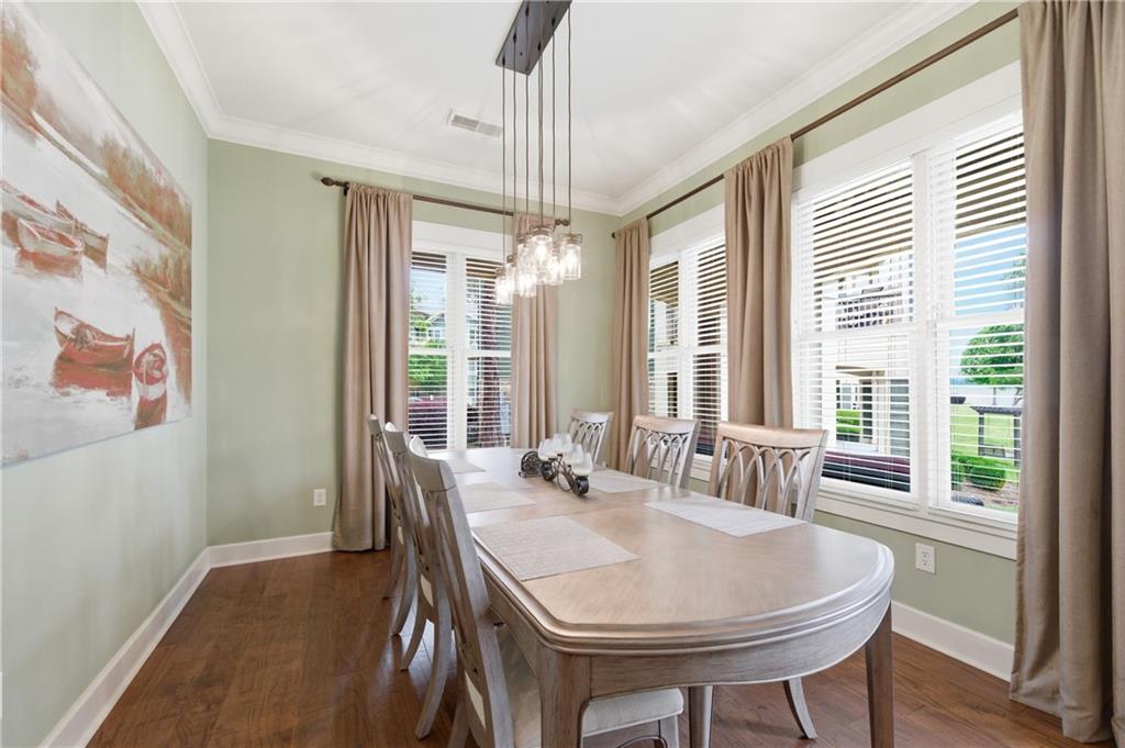 117 South Bay Road, Unit 402 Eatonton, GA 31024 - Photo 29 of 48 a dining room with furniture a chandelier and wooden floor