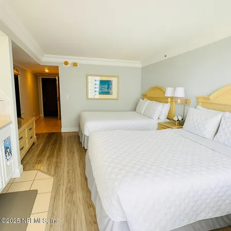 a bedroom with a bed and a flat tv screen on dresser