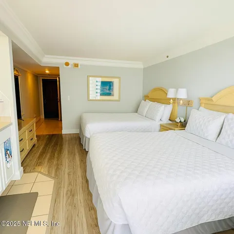 a bedroom with a bed and a flat tv screen on dresser